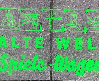 Schriftzug Alte-Welt-Spiele-Wagen mit Kreide auf Beton